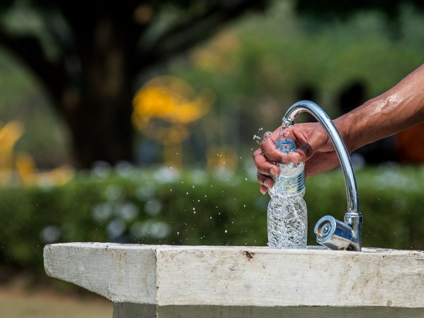 Homem enche garrafa d'água em parque na zona oeste de São Paulo (Foto: Marcelo Brandt/G1)