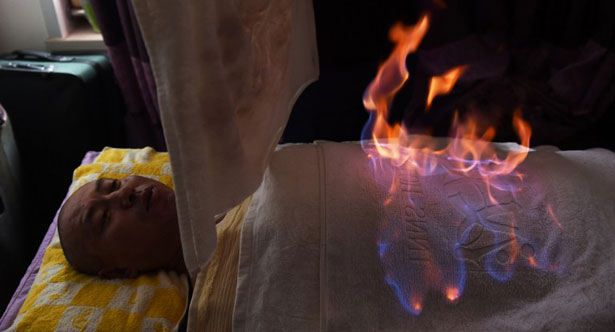 Na China, são muitos os que acreditam que o fogo faz bem para a saúde. A prevenção contra queimaduras às vezes se resume a um simples balde d'água, colocado no chão (GREG BAKER / AFP)