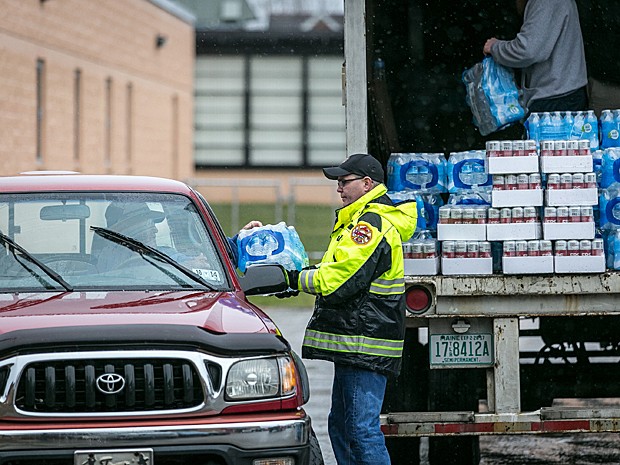 Bombeiros voluntários distribuem água a moradores neste sábado (11) após vazamento químico na sexta-feira (10) em Charleston, no estado americano de West Virginia (Foto: Michael Switzer/AP)